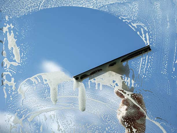 Window cleaner using a squeegee to wash a window